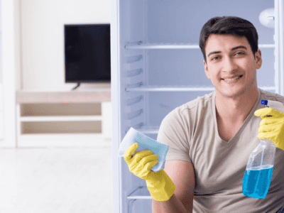 Man smiles while holding a cleaning spray